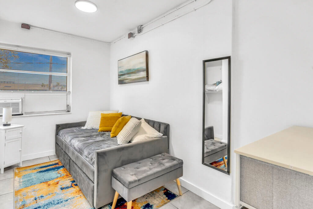 Светлая комната с серым диваном